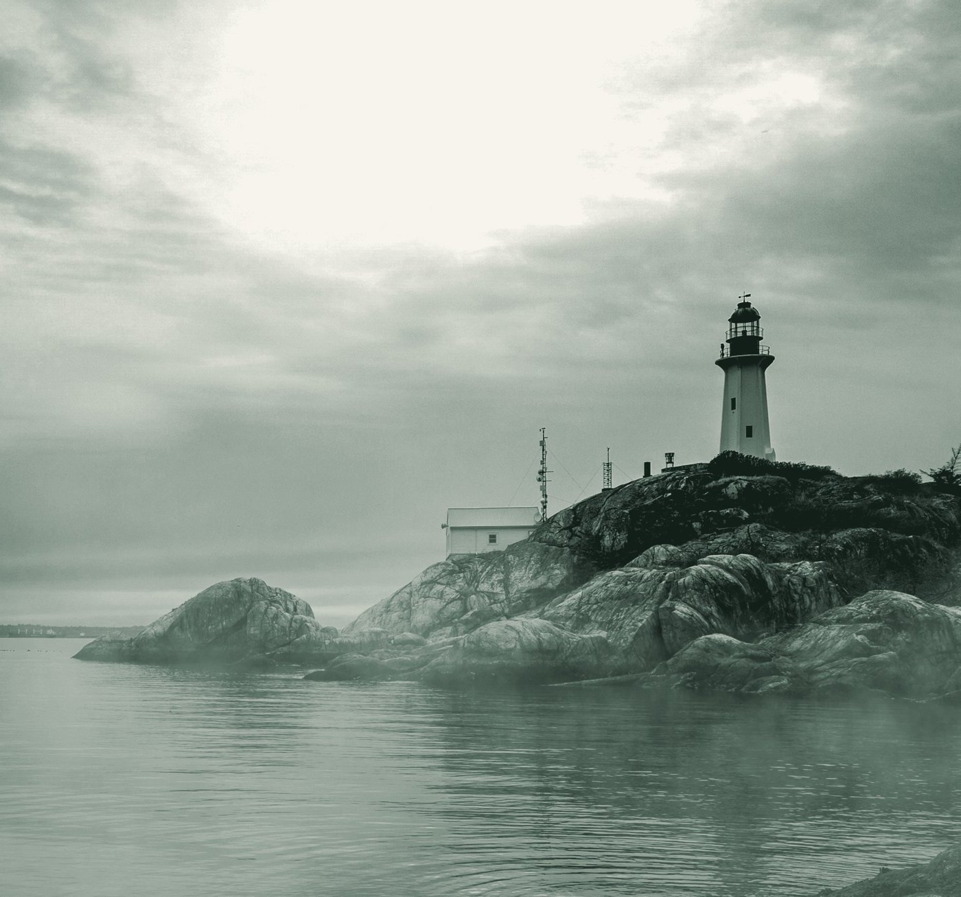 A lighthouse standing on a rock headland above open water